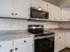 Close up of modern stainless steel stove and microwave surrounded by white cabinets at 3734 Lacebark Dr, Indianapolis, IN 46235
