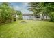 Backyard with a firepit, lush green grass and mature trees at 400 E 34Th St, Anderson, IN 46013