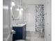 Updated bathroom features stylish marble floors, a blue vanity and a shower-tub combo at 400 E 34Th St, Anderson, IN 46013