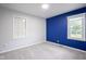 Bedroom with gray walls, blue accent wall, two windows, and plush carpet at 400 E 34Th St, Anderson, IN 46013