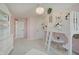 A cozy, pink bedroom features a unique loft bed with decorative accents and a charming chandelier at 4163 Ironclad Dr, Bargersville, IN 46106