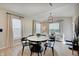 Bright dining room with black-seated chairs, a round table, modern chandelier, and large windows at 4163 Ironclad Dr, Bargersville, IN 46106