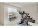 Neutral exercise room features a treadmill, exercise bike and bench seating by a window overlooking backyard at 4163 Ironclad Dr, Bargersville, IN 46106
