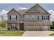 Charming two-story home showcasing a blend of brick and gray siding, complemented by a well-manicured lawn at 4163 Ironclad Dr, Bargersville, IN 46106
