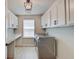 This well-organized laundry room boasts ample storage, a utility sink, and modern appliances for convenience at 4163 Ironclad Dr, Bargersville, IN 46106