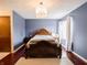 Cozy bedroom with hardwood floors, chandelier lighting, and a large bed at 4382 Castlebay Way, Indianapolis, IN 46254