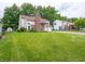View of the home's exterior with green lawn and mature trees at 4382 Castlebay Way, Indianapolis, IN 46254
