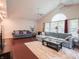 Bright living room with hardwood floors, vaulted ceiling, large windows, and comfortable seating at 4382 Castlebay Way, Indianapolis, IN 46254