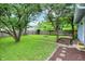 A well-maintained backyard with a fire pit, grass, trees, pavers, and a wood fence in the background at 4641 Crittenden Ave, Indianapolis, IN 46205