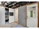An unfinished basement with exposed duct work, concrete floors, and multiple doors in the background at 4641 Crittenden Ave, Indianapolis, IN 46205