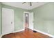 Bedroom with sage green walls, hardwood floors, and white trim, showcasing a doorway and a closet door at 4641 Crittenden Ave, Indianapolis, IN 46205