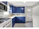 Updated kitchen features blue cabinets, modern appliances, and patterned tile floors at 4641 Crittenden Ave, Indianapolis, IN 46205