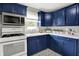 Kitchen with blue cabinets, stainless appliances, and bright white countertops at 4641 Crittenden Ave, Indianapolis, IN 46205