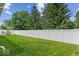 Serene backyard featuring lush green grass, a privacy fence, and mature trees at 4736 Blue Marlin Way, Indianapolis, IN 46239