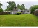 Exterior view of the home highlighting the vast backyard, featuring lush greenery and fencing at 4751 N Longworth Ave, Indianapolis, IN 46226