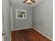 Simple bedroom with wood floors and a window for natural light at 4751 N Longworth Ave, Indianapolis, IN 46226
