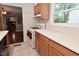 Practical kitchen with wood cabinets, white appliances, and a view into the adjacent living space at 4751 N Longworth Ave, Indianapolis, IN 46226