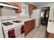 Efficient kitchen with wood cabinetry, white appliances, and tiled backsplash at 4751 N Longworth Ave, Indianapolis, IN 46226