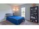 Simple bedroom with twin bed, shelving unit, natural light and neutral carpet at 488 Village Blvd, Mooresville, IN 46158
