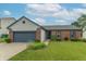 Charming single-story home featuring a brick facade, well-manicured lawn, and attached two-car garage at 488 Village Blvd, Mooresville, IN 46158
