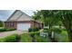 Charming brick home with a two-car garage and inviting landscaping with lush green bushes at 5189 Bally Bunion Dr, Avon, IN 46123