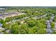 Aerial view showcases neighborhood homes nestled amongst lush trees with a view of a nearby commercial district at 5401 Padre Ln, Indianapolis, IN 46237