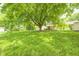 Expansive backyard with mature shade tree overlooking the home's deck and fenced yard at 5401 Padre Ln, Indianapolis, IN 46237