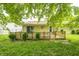 Inviting backyard featuring a wooden deck and lush lawn shaded by a mature tree canopy at 5401 Padre Ln, Indianapolis, IN 46237