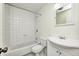 A fully-tiled bathroom with white finishes and a combination tub and shower at 5401 Padre Ln, Indianapolis, IN 46237