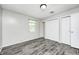Bedroom featuring gray wood floors, a closet, and natural light from the window at 5401 Padre Ln, Indianapolis, IN 46237