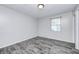 A bright bedroom features gray walls, wood-look flooring, and natural light from the window at 5401 Padre Ln, Indianapolis, IN 46237