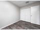 A bedroom features gray walls, wood-look flooring, natural light, and a closet for ample storage at 5401 Padre Ln, Indianapolis, IN 46237
