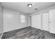 A bright bedroom features gray walls, wood-look flooring, and a closet for ample storage at 5401 Padre Ln, Indianapolis, IN 46237