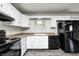 Modern kitchen featuring white cabinets, a window over the sink, and stylish black appliances at 5401 Padre Ln, Indianapolis, IN 46237