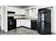 Efficient kitchen with white cabinetry, granite countertops, black appliances, and modern flooring at 5401 Padre Ln, Indianapolis, IN 46237