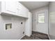 An interior laundry room boasts ample cabinet space and a view to the backyard at 5401 Padre Ln, Indianapolis, IN 46237