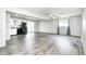 Open-concept living room and kitchen area with grey toned vinyl flooring and natural light at 5401 Padre Ln, Indianapolis, IN 46237