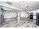 Spacious living and kitchen area featuring black appliances and stylish gray vinyl flooring at 5401 Padre Ln, Indianapolis, IN 46237