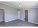 Spacious bedroom with gray walls, a pendant light, wood-look flooring and white trim and doors at 5515 W Morris St, Indianapolis, IN 46241