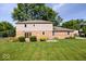 The backyard of this home offers lots of greenspace with lush lawn, mature trees and patio area at 567 Hawthorne Dr, Carmel, IN 46033