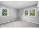 Bedroom features neutral carpet, two bright windows, and a light gray paint at 567 Hawthorne Dr, Carmel, IN 46033