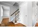 Hallway and staircase with hardwood floors and carpeted steps leading to the upper level at 567 Hawthorne Dr, Carmel, IN 46033