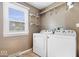 Bright laundry room with a window and shelving, plus a washer and dryer at 567 Hawthorne Dr, Carmel, IN 46033