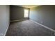 This bedroom features neutral carpet, paint, and a window providing natural light at 5683 James Blair Dr, Indianapolis, IN 46234