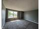 A view of a room featuring new carpet, neutral walls, and a window with a view of the outdoors at 5683 James Blair Dr, Indianapolis, IN 46234