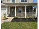 The front porch features white railings, brick pillars, and a small garden bed adding curb appeal at 5683 James Blair Dr, Indianapolis, IN 46234