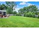 Spacious backyard with lush green lawn, mature trees, a privacy fence, and outdoor seating on the patio at 572 Quail Ridge Dr, Westfield, IN 46074