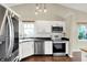 Modern kitchen features stainless steel appliances, white cabinetry, and stylish lighting fixtures at 572 Quail Ridge Dr, Westfield, IN 46074