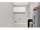 Functional laundry room with white cabinets, water heater, and updated water filtration system at 572 Quail Ridge Dr, Westfield, IN 46074