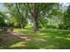 Large backyard with mature trees, a trampoline, and a swing set at 5811 Simmul Cir, Indianapolis, IN 46221